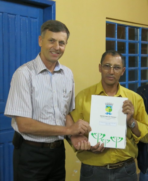 Mr. Antônio Florêncio Brandão gets the title to the association’s lot from Mayor Luizão Goularte. The lot was donated to the association by the former owners for the development of community activities.
